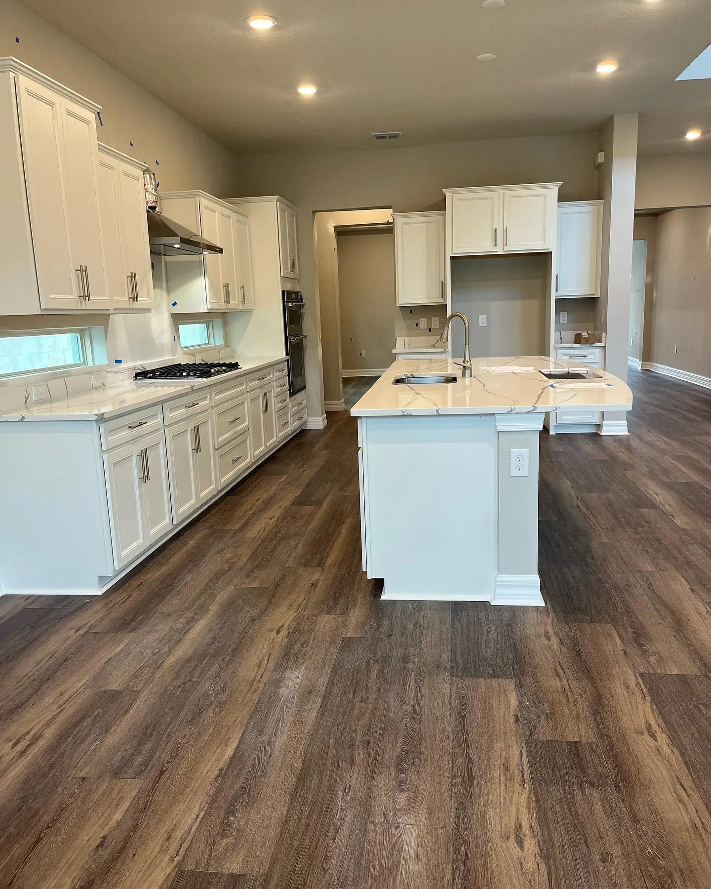 Premium vinyl plank flooring in a modern Central Florida kitchen with white cabinets and marble countertops