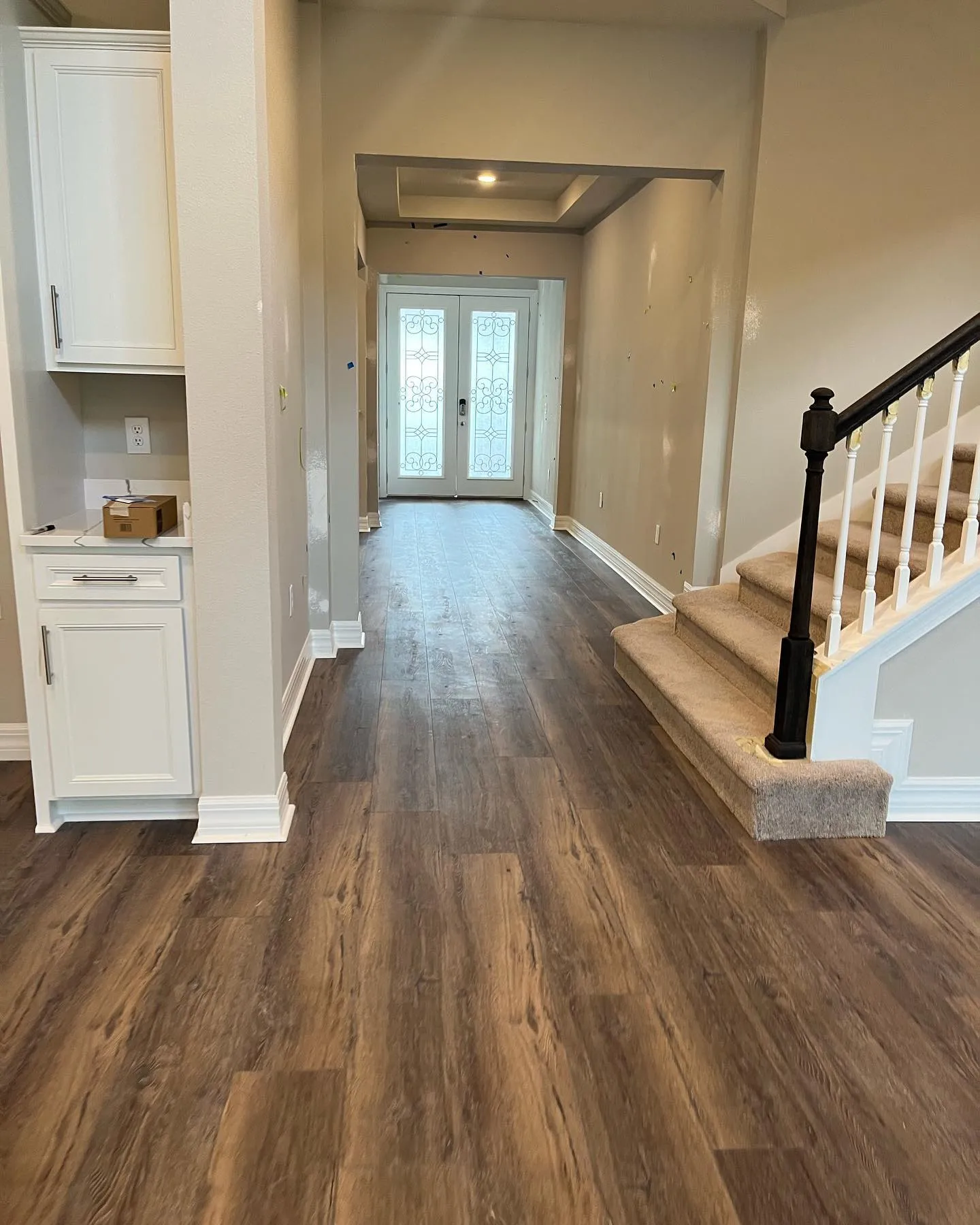 Entryway with vinyl plank flooring, baseboards, and staircase